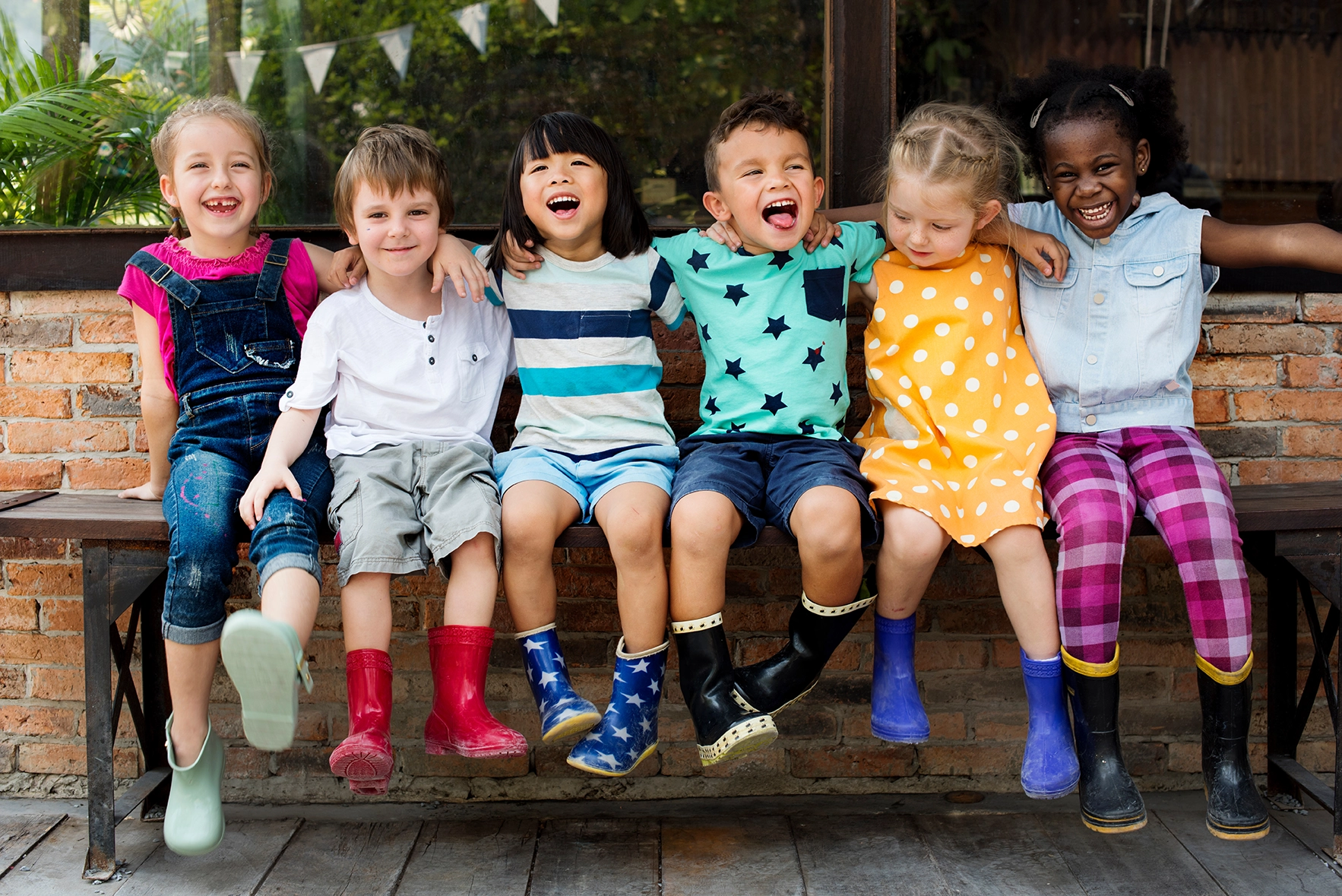 children sitting on bench and smiling